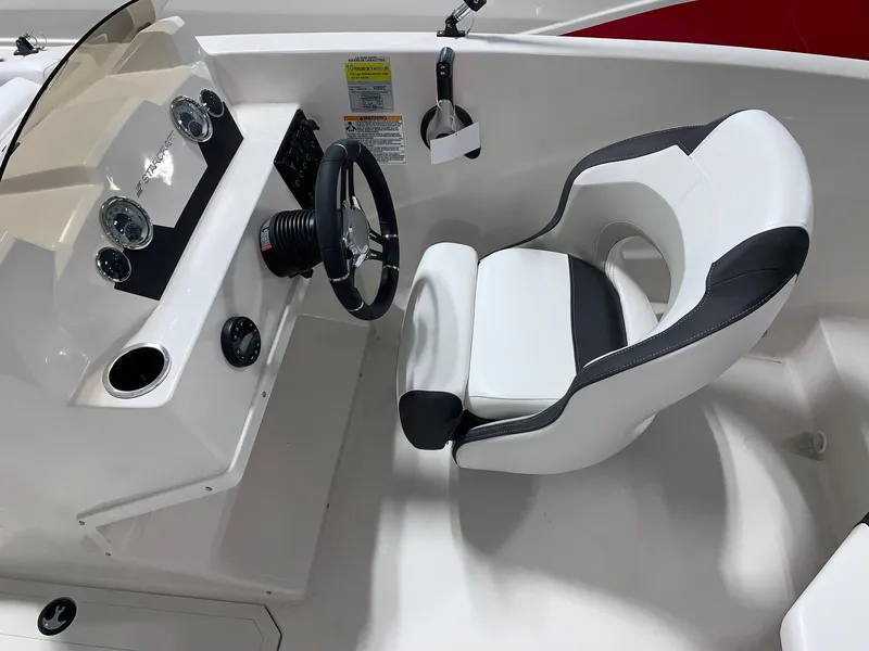 Slide: The Image of 2024 Starcraft SVX 171 boat cockpit with steering wheel and captain's chair. - 5