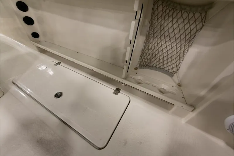 Slide: The Image of 2023 Sailfish 316 DC boat storage compartment with netting and hatch. - 23