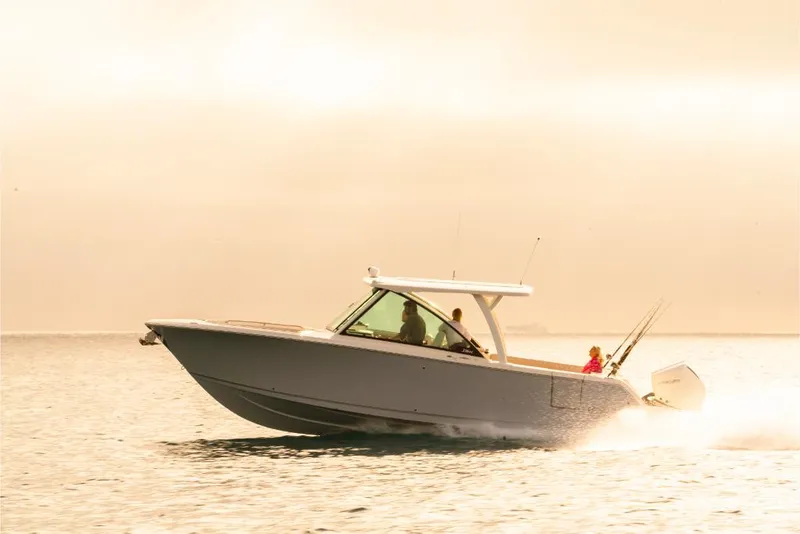 Slide: The Image of 2023 Sailfish 316 DC boat cruising on calm water at sunset. - 39
