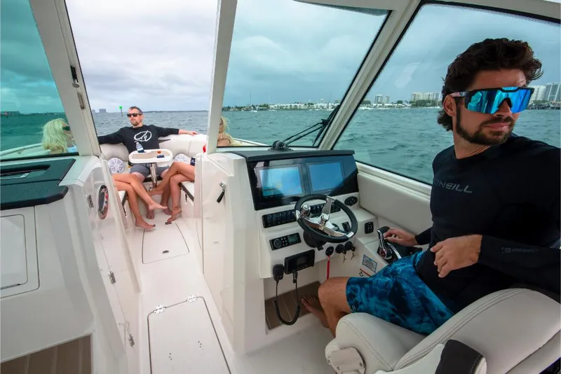 Slide: The Image of 2023 Sailfish 316 DC boat interior with people enjoying a day on the water. - 45