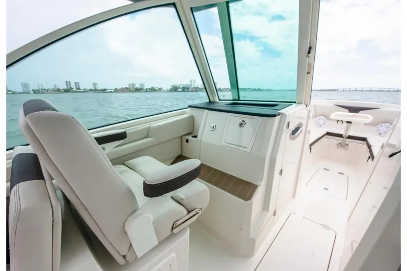 Slide: The Image of 2023 Sailfish 316 DC boat interior with white seating and ocean view. - 47