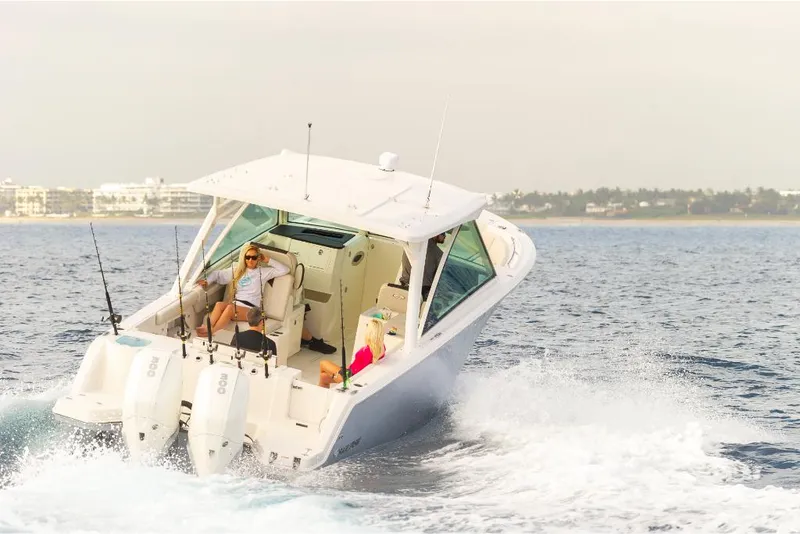 Slide: The Image of 2023 Sailfish 316 DC boat cruising on the water with two people onboard. - 6