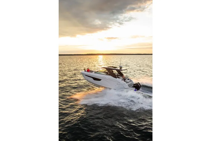 Slide: The Image of 2023 Cruisers Yachts 34 GLS I/O speeding on water at sunset. - 10