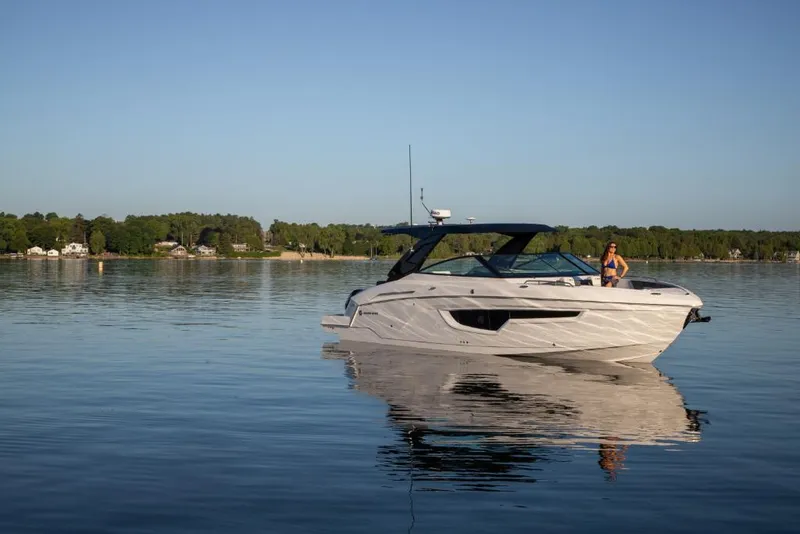 Slide: The Image of 2023 Cruisers Yachts 34 GLS I/O on calm lake with scenic background. - 12