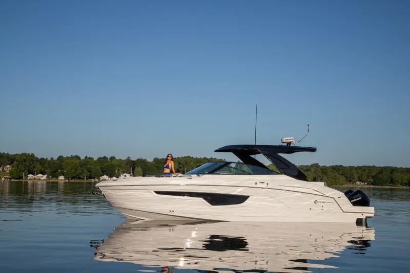 Slide: The Image of 2023 Cruisers Yachts 34 GLS I/O on calm water with scenic background. - 14