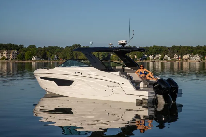 Slide: The Image of 2023 Cruisers Yachts 34 GLS I/O on a serene lake with a person relaxing. - 15