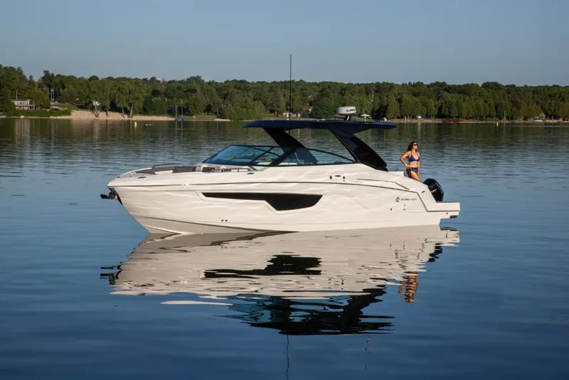 Slide: The Image of 2023 Cruisers Yachts 34 GLS I/O on a calm lake with a scenic background. - 16