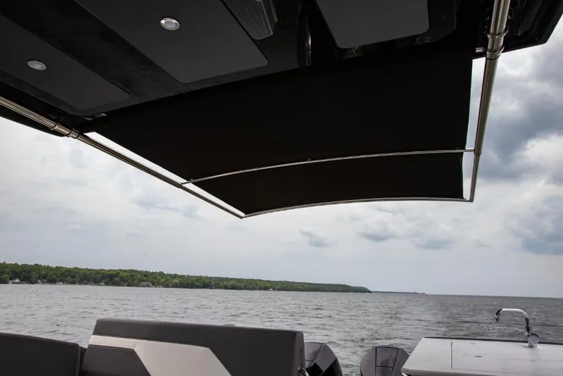 Slide: The Image of 2023 Cruisers Yachts 34 GLS I/O, rear deck view with canopy over water. - 28