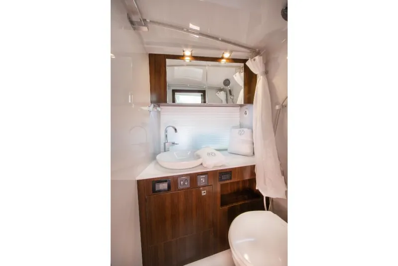 Slide: The Image of 2023 Cruisers Yachts 34 GLS I/O bathroom with modern fixtures and wooden cabinetry. - 31