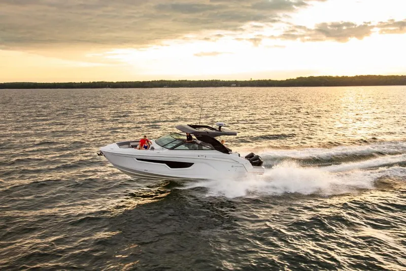 Slide: The Image of 2023 Cruisers Yachts 34 GLS I/O speeding on open water at sunset. - 4
