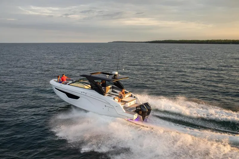 Slide: The Image of 2023 Cruisers Yachts 34 GLS I/O cruising on open water at sunset. - 6