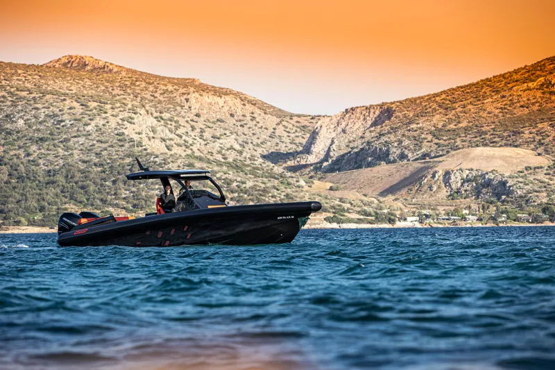 Slide: The Image of 2024 Skipper-BSK 38NC boat cruising on a scenic lake with mountainous backdrop. - 2