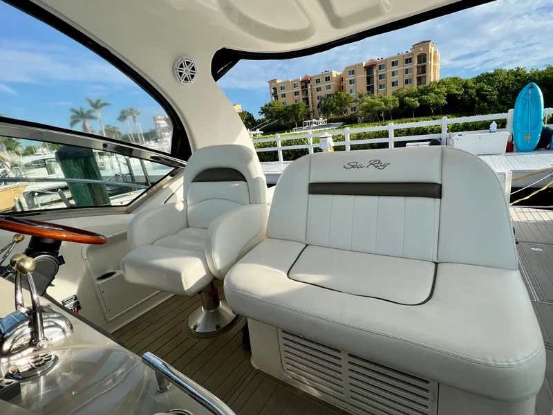 Slide: The Image of 2007 Sea Ray 40 Sundancer cockpit with white leather seating and marina view. - 17