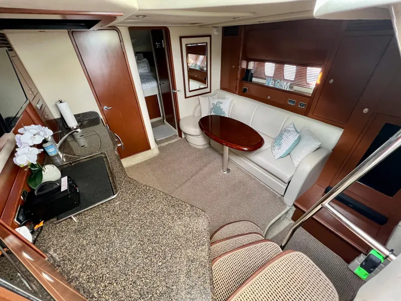 Slide: The Image of Interior of 2007 Sea Ray 40 Sundancer yacht with kitchen, seating area, and table. - 24