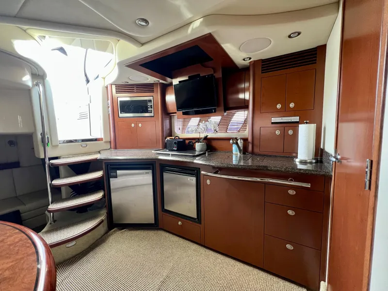 Slide: The Image of 2007 Sea Ray 40 Sundancer yacht interior kitchen with modern appliances and wooden cabinetry. - 26