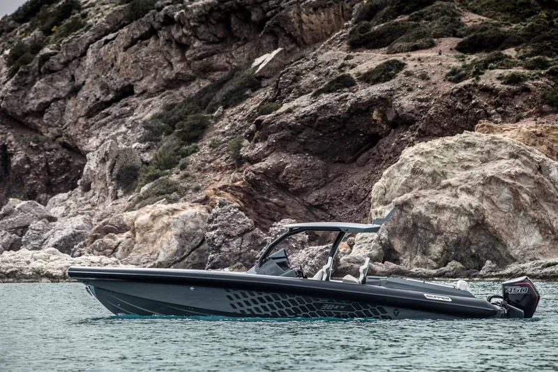 Slide: The Image of 2024 Skipper-BSK 38NC boat cruising near rocky coastline. - 49