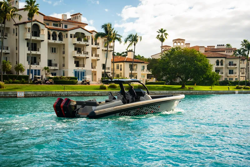 Slide: The Image of 2024 Skipper-BSK 38NC boat cruising near luxury waterfront apartments. - 2