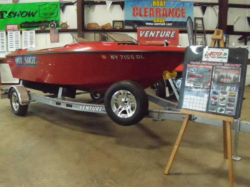 Slide: The Image of 1970 Century Mark II red boat on trailer at indoor boat show. - 2