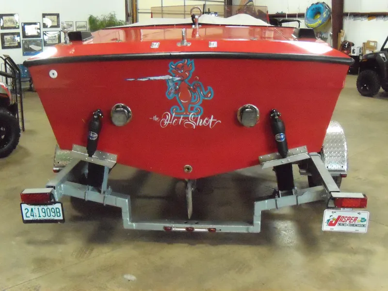 Slide: The Image of 1970 Century Mark II boat, red with Hot Shot graphic, on a trailer in a garage. - 4