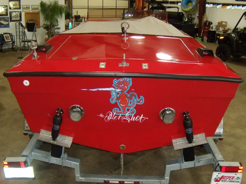 Slide: The Image of 1970 Century Mark II boat, red with Hot Shot graphic, on a trailer in a garage. - 5