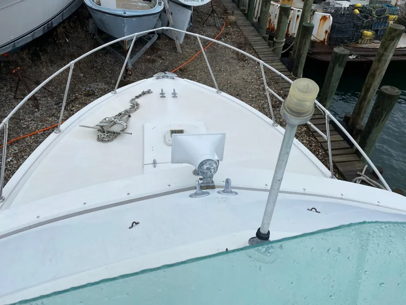 Slide: The Image of 1983 Bertram 28 FB boat bow with anchor chain and docked at marina. - 13