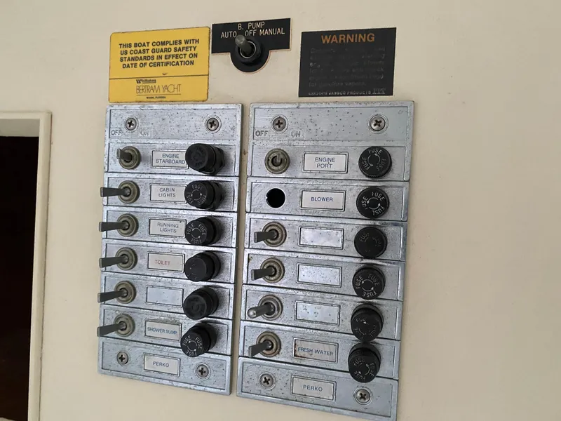 Slide: The Image of Electrical panel on 1983 Bertram 28 FB boat with labeled switches and warnings. - 15