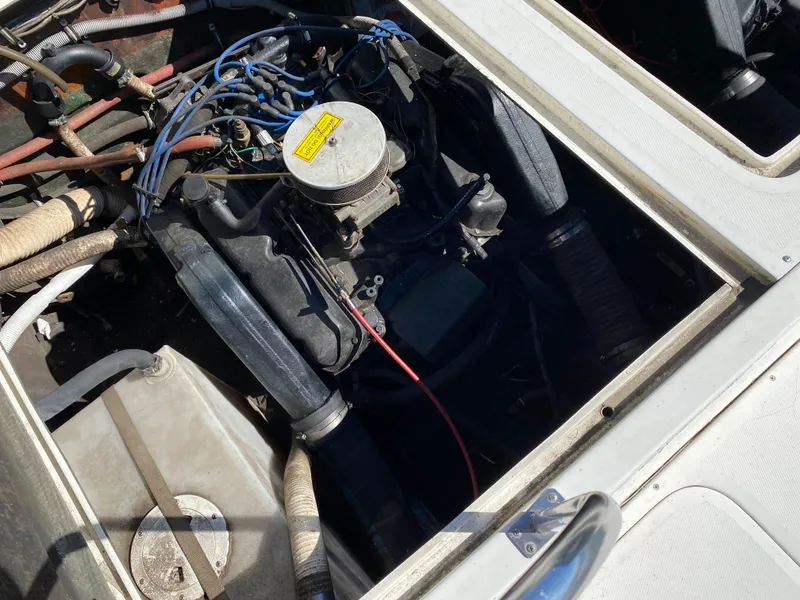Slide: The Image of 1983 Bertram 28 FB engine compartment with visible wiring and components. - 19