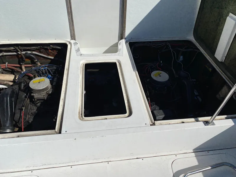 Slide: The Image of 1983 Bertram 28 FB engine compartments with open hatches, showcasing dual engines. - 20
