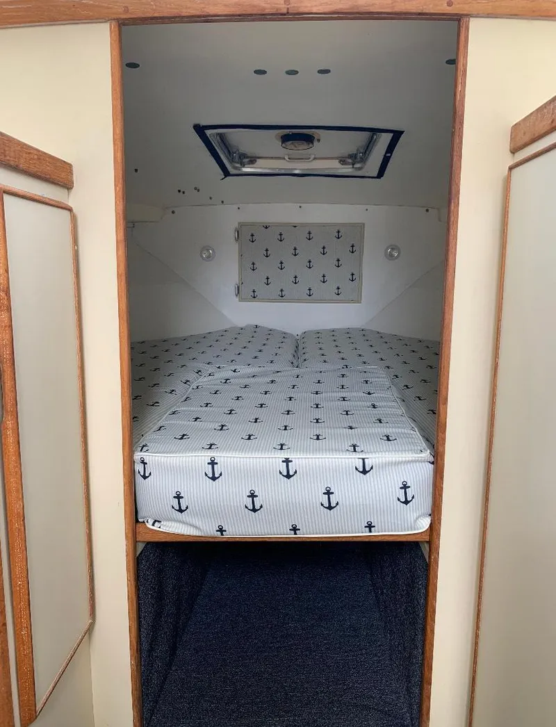 Slide: The Image of 1983 Bertram 28 FB cabin interior with anchor-themed bedding. - 5
