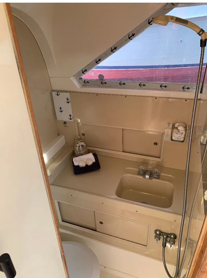 Slide: The Image of 1983 Bertram 28 FB boat bathroom with sink, shower, and storage. - 8