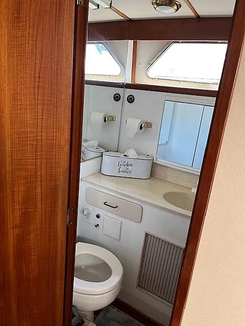 Slide: The Image of 1987 Tollycraft Sundecker Diesel yacht bathroom with wood accents and compact design. - 12