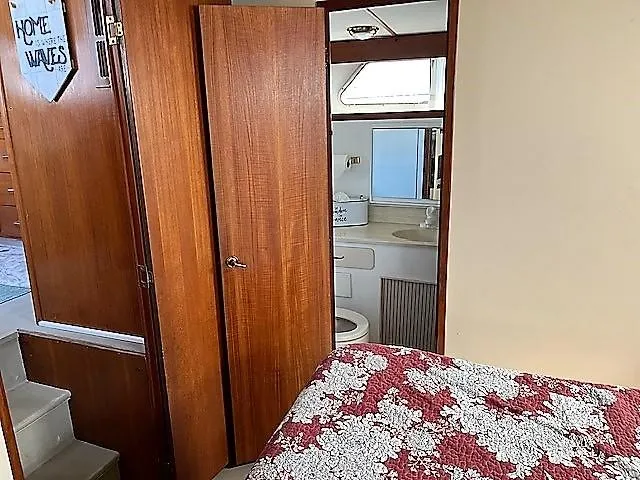 Slide: The Image of 1987 Tollycraft Sundecker interior with wood paneling, floral bedspread, and compact bathroom. - 13