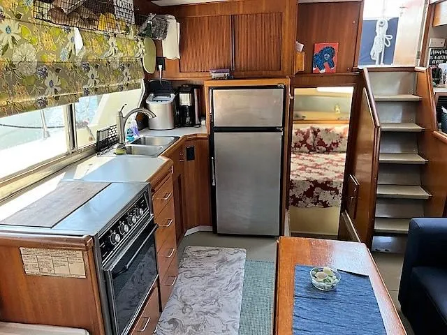Slide: The Image of 1987 Tollycraft Sundecker Diesel interior with kitchen, dining area, and stairs to cabin. - 15