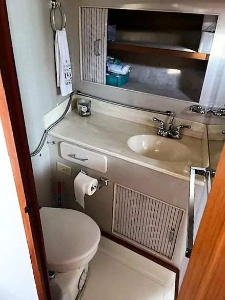 Slide: The Image of 1987 Tollycraft Sundecker Diesel yacht bathroom with sink, toilet, and storage. - 16