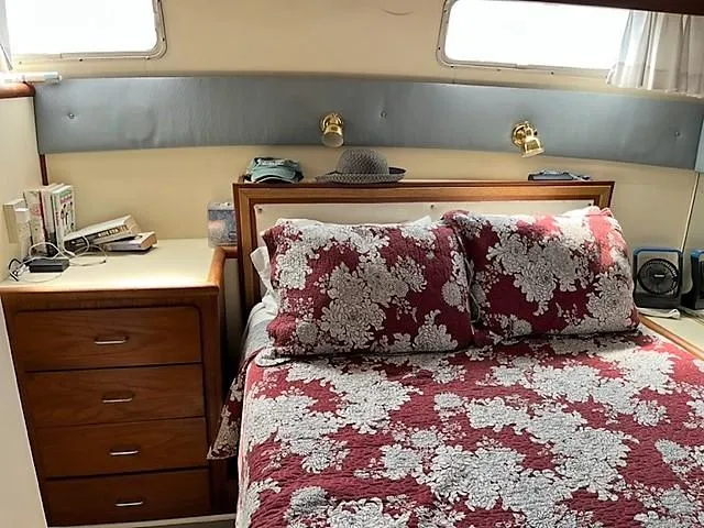Slide: The Image of 1987 Tollycraft Sundecker Diesel cabin with floral bedding and wooden furniture. - 19