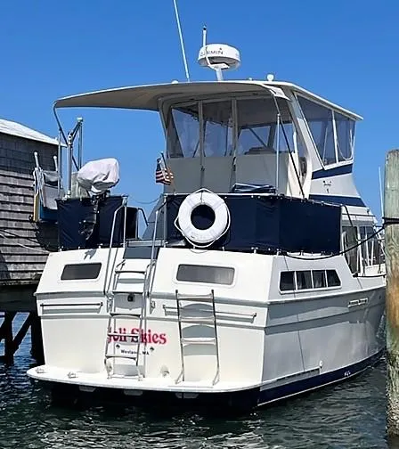 Slide: The Image of 1987 Tollycraft Sundecker Diesel yacht docked, featuring a spacious deck and classic design. - 5