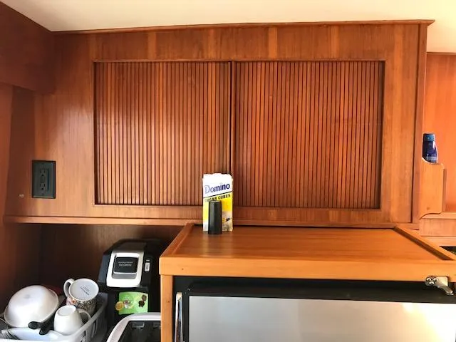 Slide: The Image of 1987 Tollycraft Sundecker Diesel interior with wooden cabinets and kitchen essentials. - 9