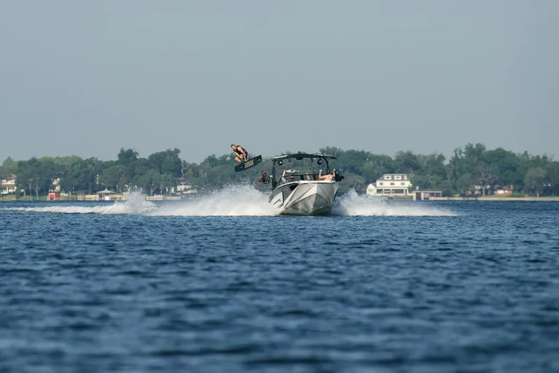 Slide: The Image of 2023 Nautique Super Air GS22E towing a wakeboarder on a lake. - 12