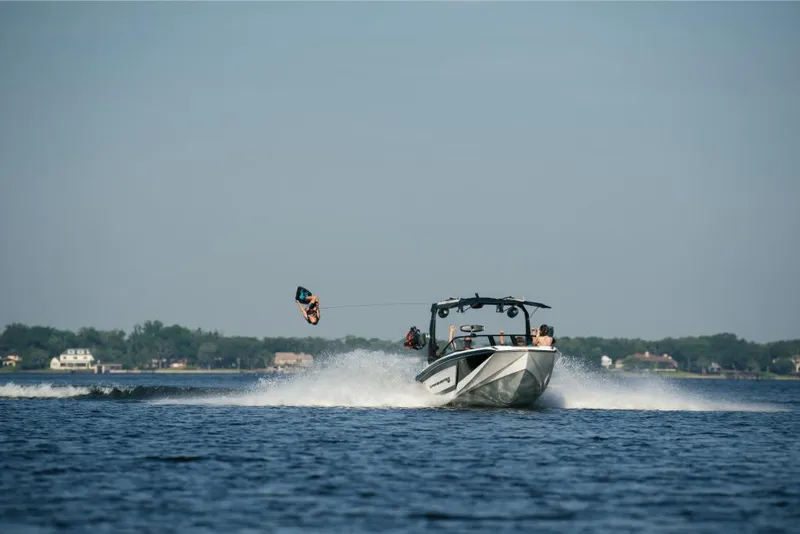 Slide: The Image of 2023 Nautique Super Air GS22E towing a wakeboarder on a lake. - 13