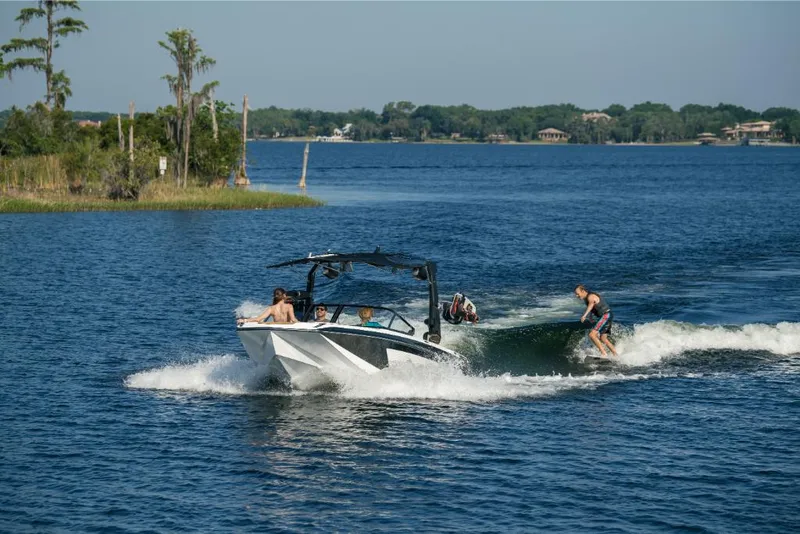 Slide: The Image of 2023 Nautique Super Air GS22E towing a wakeboarder on a scenic lake. - 16