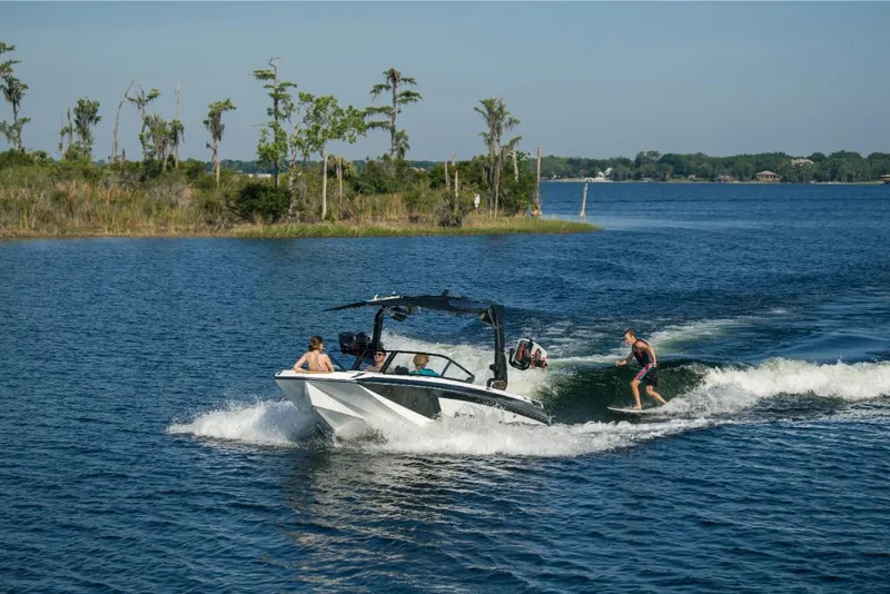 Slide: The Image of 2023 Nautique Super Air GS22E towing a wakeboarder on a scenic lake. - 17