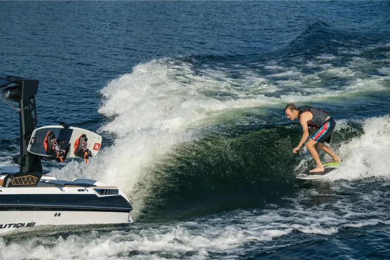 Slide: The Image of 2023 Nautique Super Air GS22E towing a wakesurfer on a lake. - 18