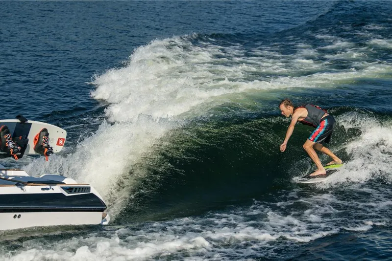 Slide: The Image of 2023 Nautique Super Air GS22E towing a wakeboarder on a lake. - 19