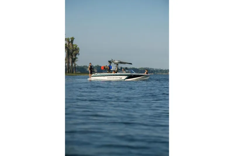 Slide: The Image of 2023 Nautique Super Air GS22E boat on a lake with people onboard. - 29