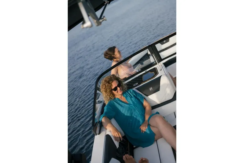 Slide: The Image of 2023 Nautique Super Air GS22E boat with passengers relaxing on the water. - 35