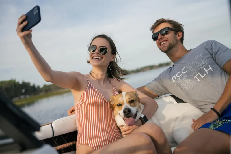 Slide: The Image of Couple and dog enjoying a ride on a 2023 Nautique Super Air GS22E boat. - 38