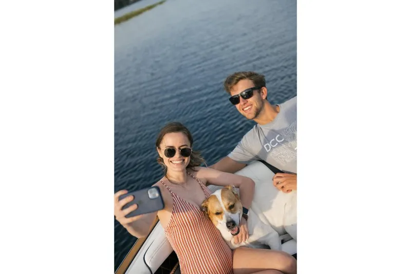 Slide: The Image of Couple with dog taking a selfie on a 2023 Nautique Super Air GS22E boat. - 41