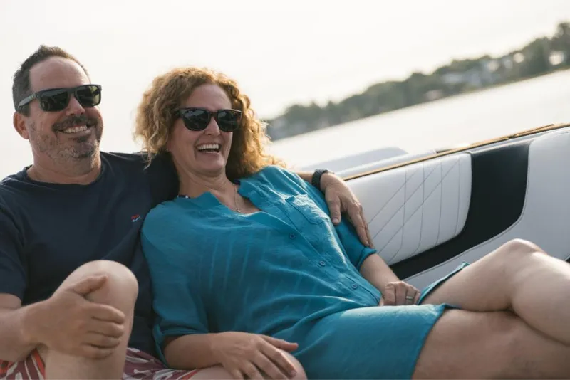Slide: The Image of Couple enjoying a ride on a 2023 Nautique Super Air GS22E boat. - 42