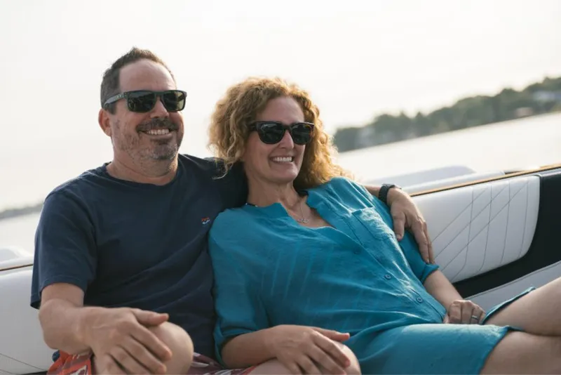 Slide: The Image of Couple enjoying a ride on a 2023 Nautique Super Air GS22E boat. - 43