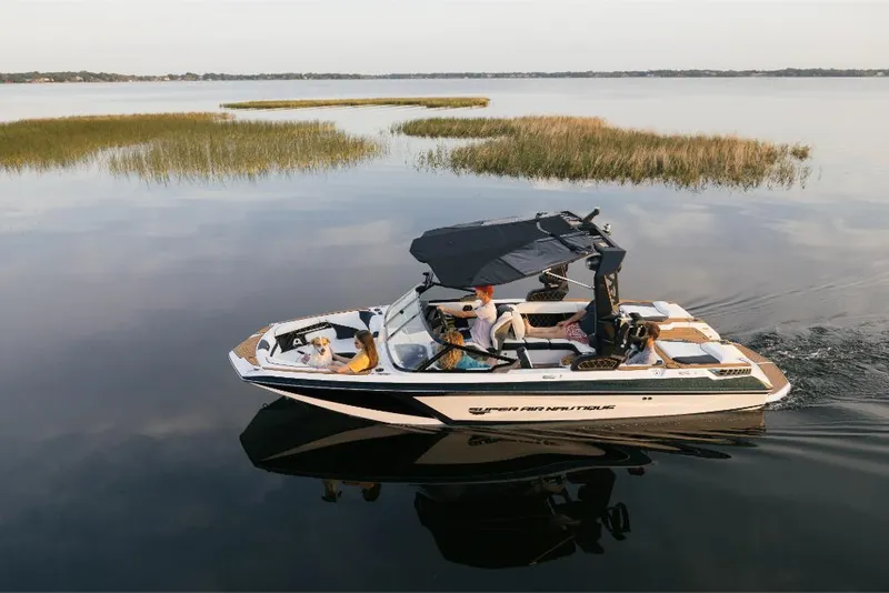 Slide: The Image of 2023 Nautique Super Air GS22E boat cruising on a calm lake. - 8